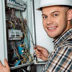 EIn Elektroniker der an einem Verteilerkasten arbeitet