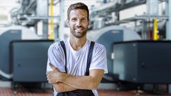 Ein Mann in Arbeitskleidung mit verschränkten Armen